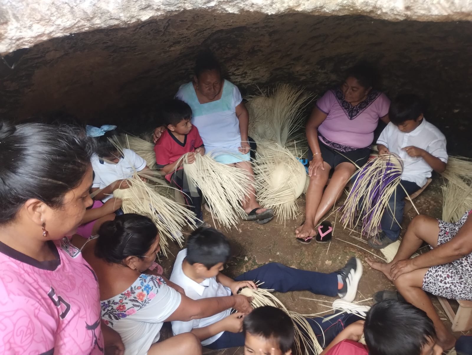 Ocho mujeres mayas tejen sombreros de guano
